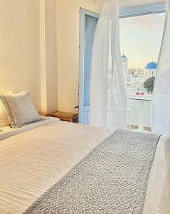 ein Schlafzimmer mit einem Bett und einem großen Fenster in der Unterkunft Villa Fotini in Firostefani