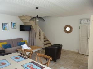 salon z kanapą i schodami w obiekcie Maison de vacances 3* à 50m de la plage w mieście Tréffiagat