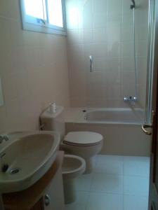 uma casa de banho com um WC, uma banheira e um lavatório. em Bonito piso frente al puerto de Sada em Sada