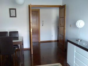 Cette chambre dispose d'une porte, d'un bureau et d'une table. dans l'établissement Bonito piso frente al puerto de Sada, à Sada