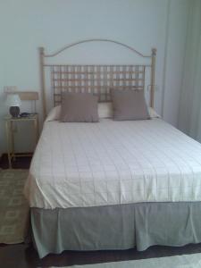 um quarto com uma cama branca e uma cabeceira em madeira em Bonito piso frente al puerto de Sada em Sada
