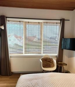 - une chambre avec un lit, une fenêtre et une chaise dans l'établissement Appartement Zuid 5, à Zandvoort