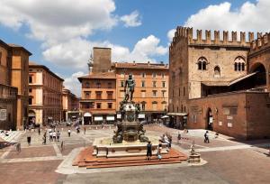 a group of people walking around a plaza with a statue at Grand Hotel Elite in Bologna