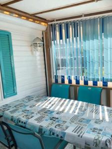 een tafel en stoelen in een kamer met een raam bij Bungalow de 2 chambres avec piscine partagee et terrasse amenagee a La Baule Escoublac in Saint-André-des-Eaux