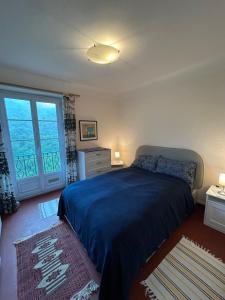 a bedroom with a bed and a large window at Castillon - Maritime Alpes in Castillon