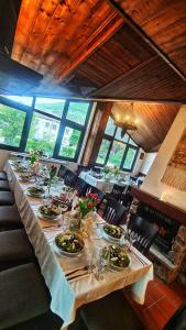 una sala da pranzo con un lungo tavolo con piatti di cibo di Hotel Kiprovets a Chiprovtsi