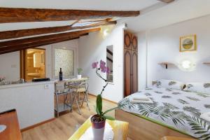 a bedroom with a king sized bed and a kitchen at Apartments Viola by Rent Istria in Momjan