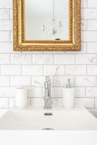 a bathroom sink with a gold framed mirror above it at Keszthely Balaton Luxury Villa in Keszthely