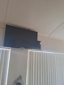 una televisione in cima a una parete in una stanza di Breaking Dawn a Noupoort
