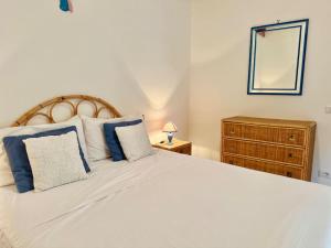 ein Schlafzimmer mit einem großen weißen Bett mit blauen Kissen in der Unterkunft Onde del mar in Meta