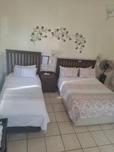 dwa łóżka siedzące obok siebie w sypialni w obiekcie Breaking Dawn w mieście Noupoort