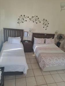 Dos camas una al lado de la otra en un dormitorio. en Breaking Dawn, en Noupoort