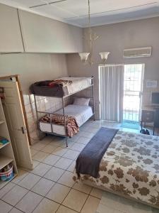 - une chambre avec des lits superposés et du carrelage dans l'établissement Breaking Dawn, à Noupoort