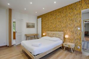 1 dormitorio con cama y pared amarilla en La Villa Océane — Beach & old presbytery en Lion-sur-Mer