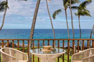 a table and chairs on a balcony with the ocean at Kona Isle E23 in Kailua-Kona
