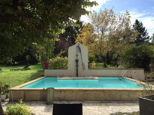 a swimming pool with a fountain in a yard at Les Colonnes De Chanteloup in Amboise