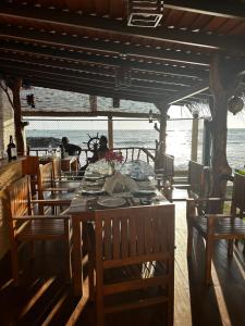 een eetkamer met een tafel en stoelen en de oceaan bij White Sand Villa - Beach front in Hikkaduwa