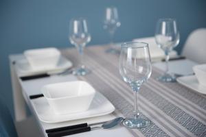 a table with wine glasses and plates on it at Apartamenty Emilia 2 in Gniezno