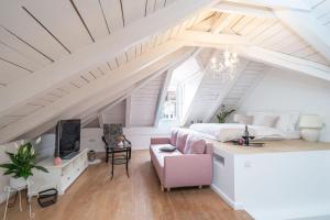 Schlafzimmer im Dachgeschoss mit einem Bett und einem rosa Stuhl in der Unterkunft FORTUNATA Apartment in Dubrovnik