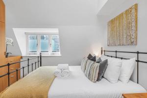 1 dormitorio con 1 cama con sábanas y almohadas blancas en Pass the Keys Barbican Gem en Londres