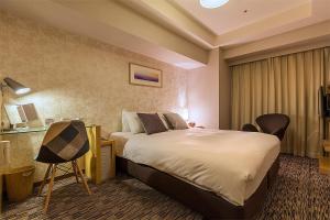 札幌市にあるホテルリソルトリニティ札幌のベッドとデスクが備わるホテルルームです。