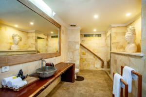 een badkamer met een wastafel, een spiegel en een bad bij Aryaswara Villa Ubud in Ubud