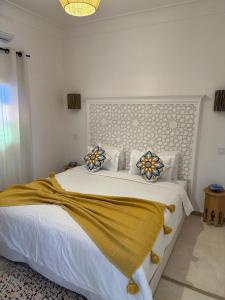a bedroom with a large bed with a yellow blanket on it at Dar Julia in Marrakesh