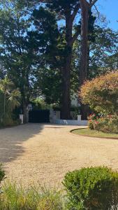 a park with trees and a path with flowers and plants at Maison Cuevas in Biarritz