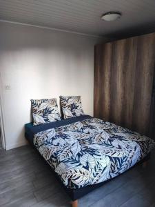 a bedroom with a bed with blue and white sheets at La Caz Serins ETANG SALE in Le Lambert