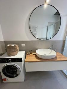 uma casa de banho com uma máquina de lavar roupa e um espelho. em Casa Moci em Verona