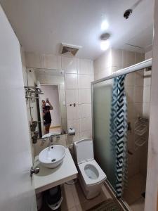 eine Person, die ein Bild von einem Bad mit WC und Waschbecken macht in der Unterkunft Birch Tower Studio Condo - Staycation in Manila in Manila