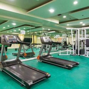 einen Fitnessraum mit Laufbändern und Crosstrainern in der Unterkunft Birch Tower Studio Condo - Staycation in Manila in Manila