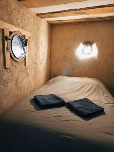 een bed in een kamer met twee kussens erop bij La maison Sacquet in Saint-Sulpice-les-Feuilles