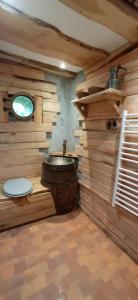een houten badkamer met een toilet en een wastafel bij La maison Sacquet in Saint-Sulpice-les-Feuilles