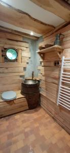 a wooden bathroom with a toilet and a sink at La terre du milieu 87 in Saint-Sulpice-les-Feuilles