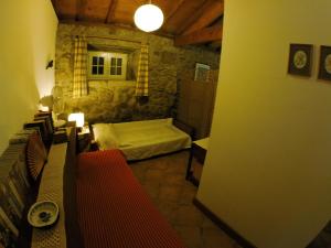 a bedroom with a bed in a stone room at Casa do Ribeiro - Casal Pedro in Ponte de Lima