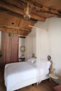 1 dormitorio con cama blanca y techo de madera en CASAS DA FORTALEZA Casa do Garda, en Outeiro de Rei