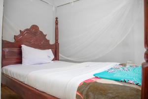 a bedroom with a bed with a canopy at KaribuGuestHouse in Fort Portal