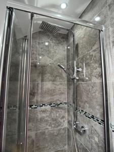 une douche avec une porte vitrée dans une salle de bain dans l'établissement Cosy 1 Bed Flat with Free Parking, à Birmingham