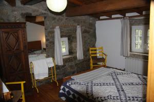 a bedroom with a bed and a table and chairs at Casa do Ribeiro - Casal Pedro in Ponte de Lima +55 photos
