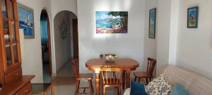 サンタ・ポラにあるApartamento Carmenのテーブルと椅子、壁画が備わる客室です。