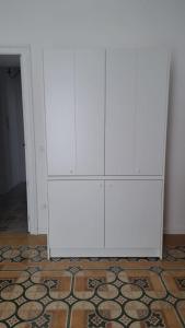 une armoire blanche dans une chambre avec un tapis dans l'établissement Dimora Savarino Marzamemi Suites with pool, à Marzamemi