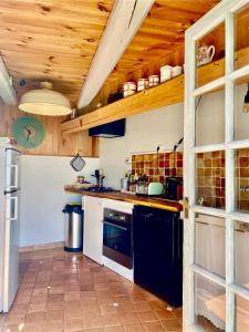 a kitchen with wooden ceilings and a stove top oven at Le 1830 in Églisolles