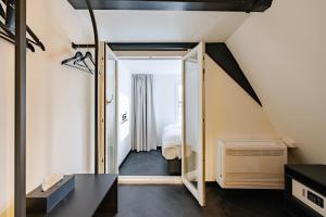 Habitación con una puerta que conduce a un dormitorio en SUPPER Hotel en Ámsterdam
