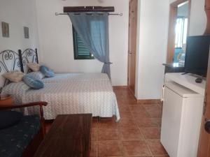 a bedroom with a bed with blue pillows on it at Casa Rural El Cubillo in Vejer de la Frontera