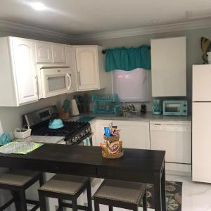 a kitchen with white cabinets and a table with chairs at The Haven Hideaway & Platinum in Freeport