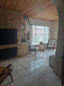 a living room with a tv on a brick wall at Breaking Dawn in Noupoort