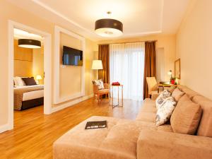 فندق نيديا ايسينيورت  في إسطنبول: غرفة معيشة مع أريكة وسرير