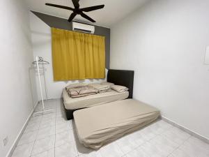 two beds in a room with a ceiling fan at 8min Port Dickson beach 17pax Pet Friendly in Port Dickson