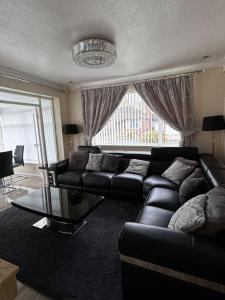 a living room with a couch and a glass table at 230 Councillor Lane in Cheadle